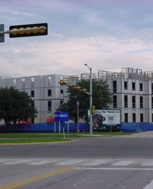 Multi-story panel building framed to roofline near street intersection