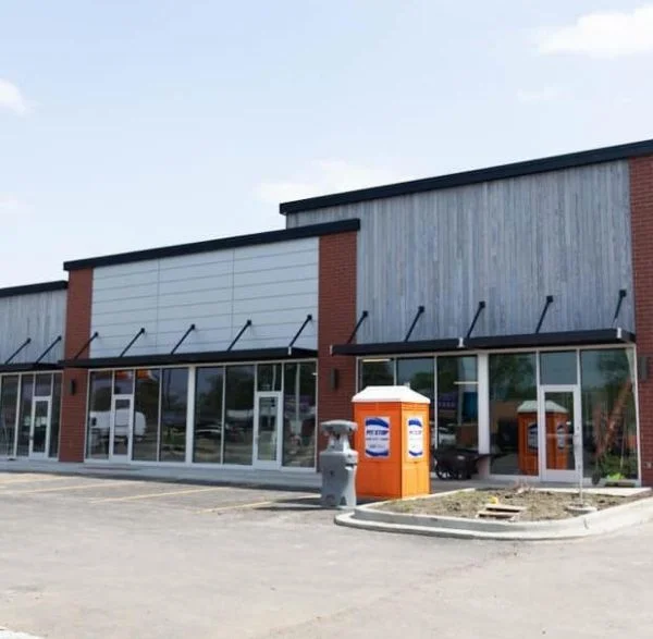 Single-story retail strip building with brick and panel exterior