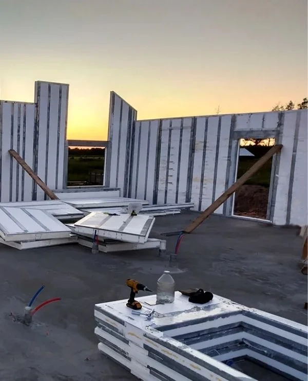 SIP panel walls assembled on a foundation slab at sunset