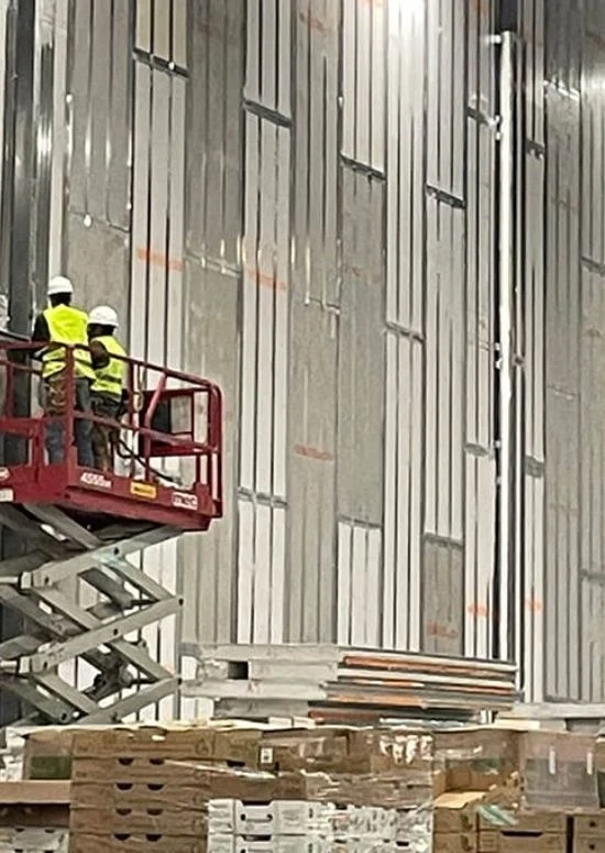 Michigan (4) Workers on lift installing panel walls inside warehouse structure
