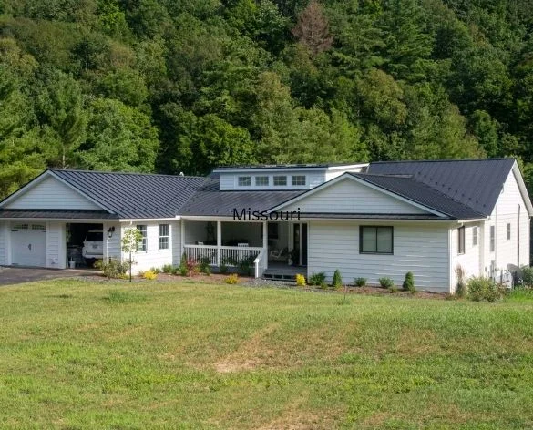 Single-story ranch home with metal roof and covered porch