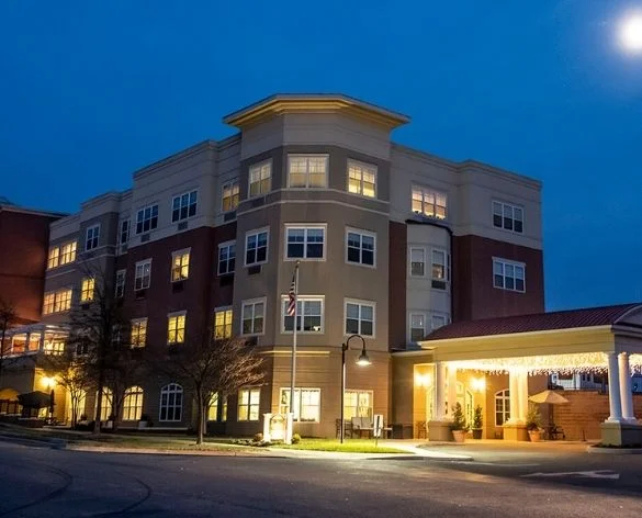 Multi-story building illuminated at night with covered entrance