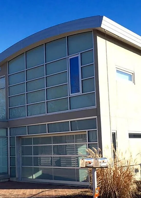 Modern home with curved roofline and glass panel walls