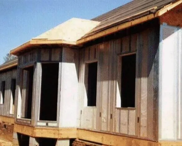 Single-story home under construction with hip roof framing