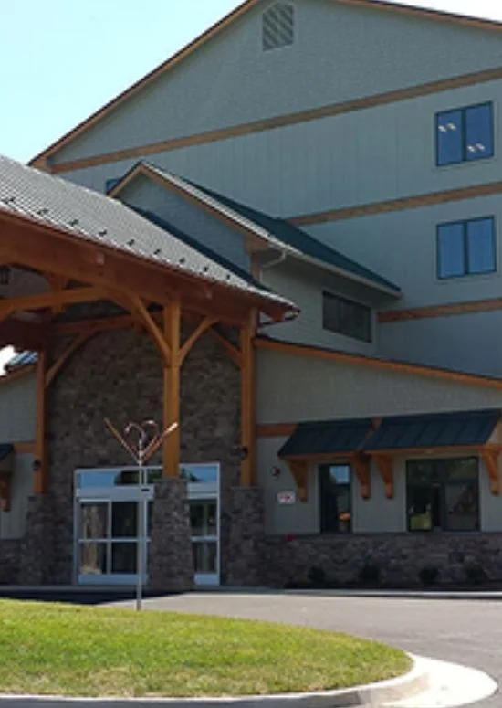 Lodge-style building with timber entrance canopy and stone base