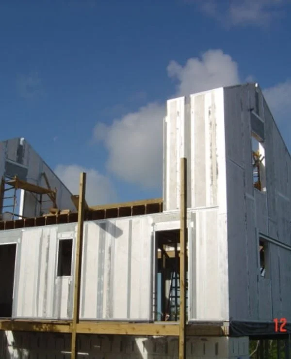 Two-story panel structure under construction with scaffolding