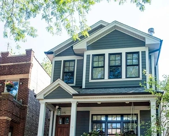 Two-story craftsman home with dark siding and covered porch