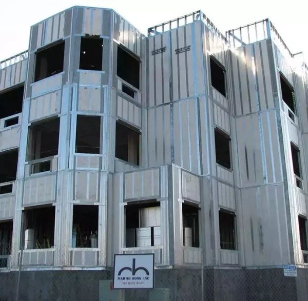 Multi-story panel building under construction with framed openings