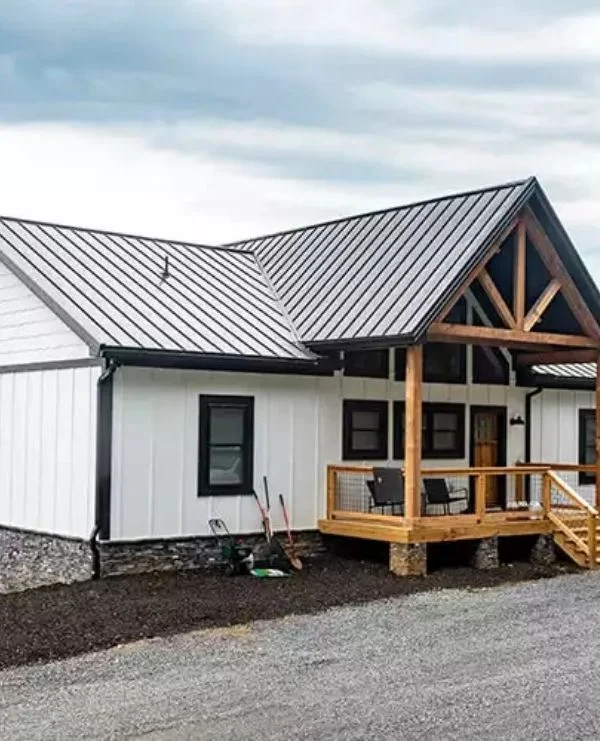 Farmhouse-style home with metal roof and timber-framed porch