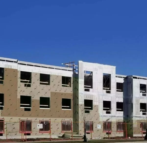 Multi-story panel building under construction in snow