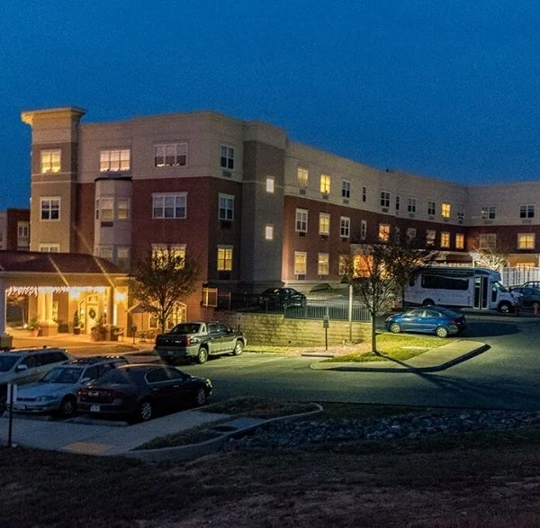 Washington DC (3) Multi-story building illuminated at dusk with parked vehicles